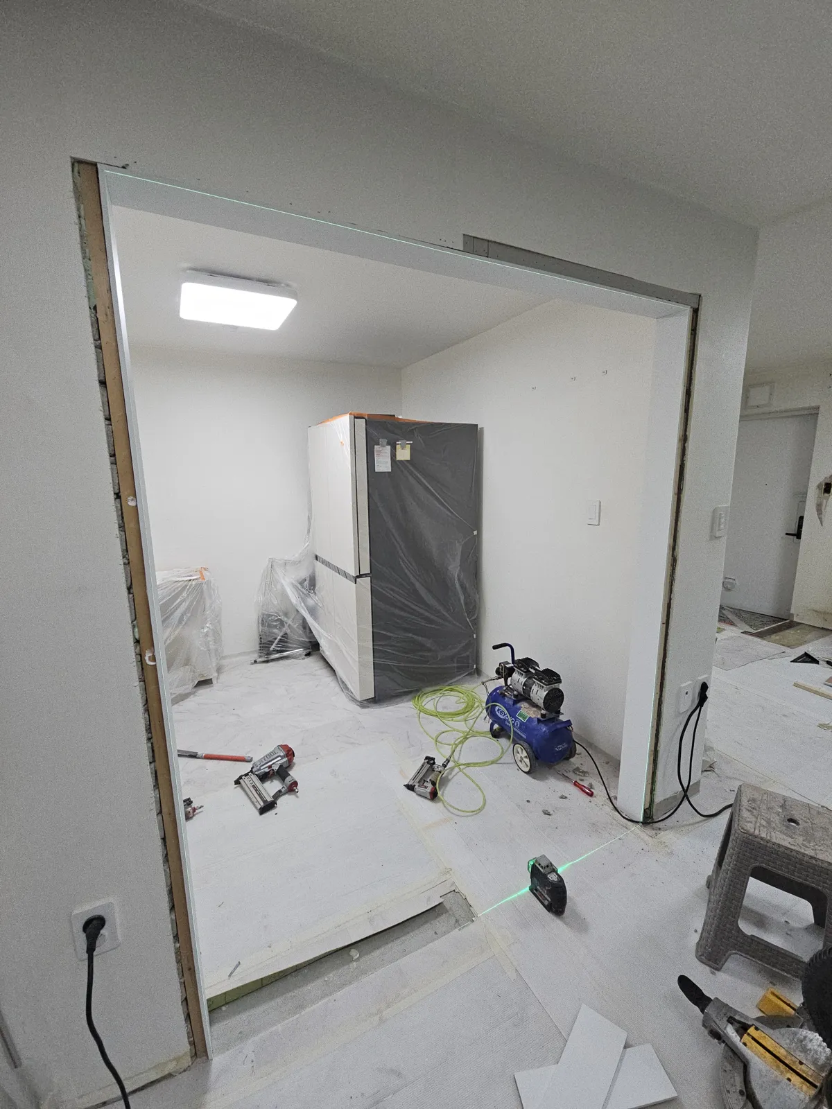 문틀 라인을 맞춘 뒤 보양 작업 중인 출입구